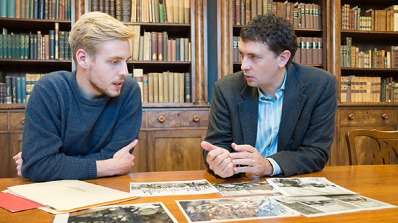 MAX WIELAND '17, and Associate Professor of History Edward Miller discuss photos for the Dartmouth Vietnam Project