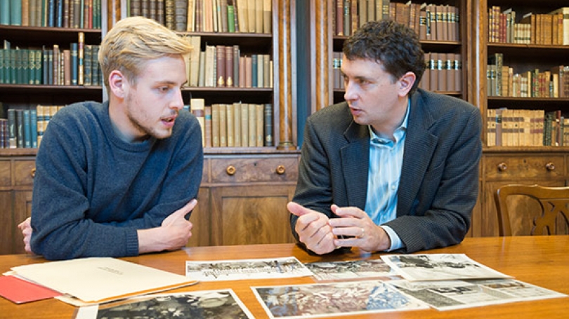 MAX WIELAND '17, and Associate Professor of History Edward Miller discuss photos for the Dartmouth Vietnam Project